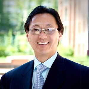 Professional headshot of a male physician in a navy suit and glasses at Modern Woman Med Spa Santa Rosa
